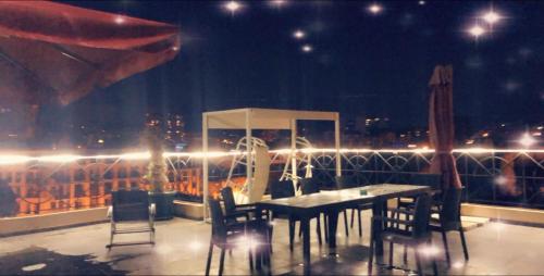 a table and chairs on a balcony at night at Schöne Wohnung mitten im Zentrum von Batumi in Batumi