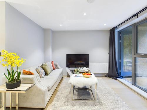 a living room with a couch and a table at Wild Roses Serviced Apartments - Lake District in Backbarrow