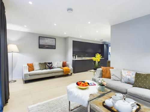 a living room with a couch and a table at Wild Roses Serviced Apartments - Lake District in Backbarrow
