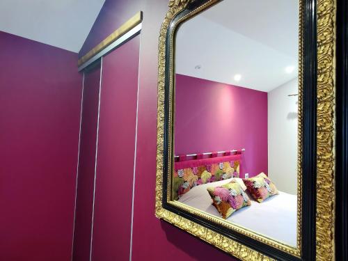 - une chambre avec des murs violets et un miroir dans l'établissement Gîte charmant avec terrasse et wifi au Puy-en-Velay - FR-1-582-331, au Puy-en-Velay