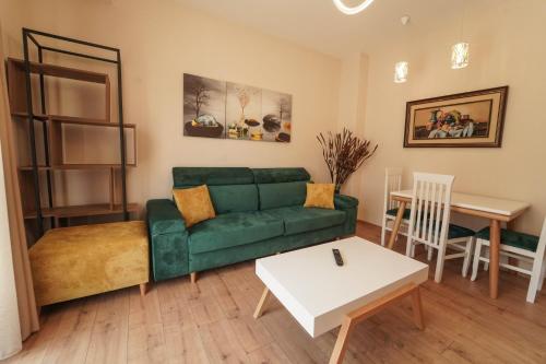 a living room with a green couch and a table at Haris Apartments Tirana in Tirana
