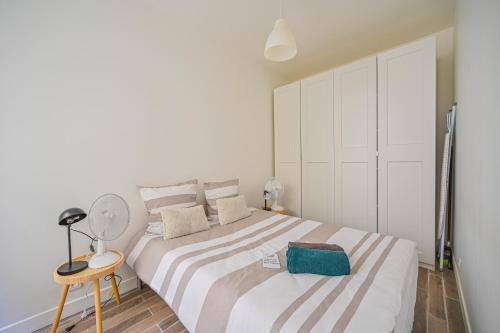 une chambre blanche avec un grand lit et une table dans l'établissement Appartement Suite Truffaut, à Paris