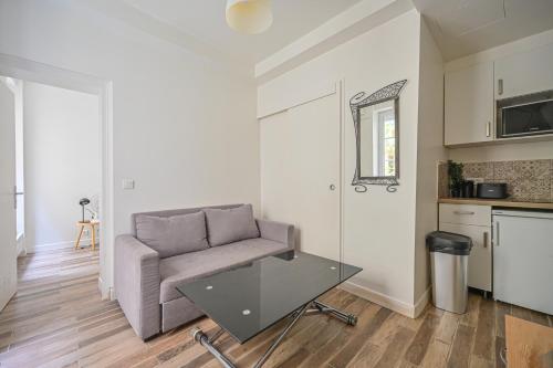 un salon avec un canapé et une table dans l'établissement Appartement Suite Truffaut, à Paris