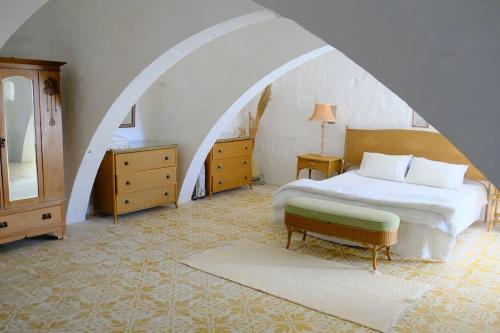 a bedroom with a bed and a chair and a mirror at Casa Palma Gozo in Għarb
