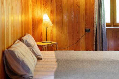 a bedroom with a bed with a lamp on a table at La Libellula in Scopello