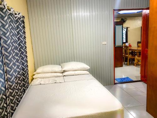 a bed with two pillows in a room at Tina Homestay in Burgos
