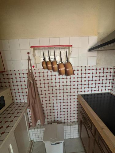 une cuisine avec des ustensiles en cuivre sur un mur carrelé dans l'établissement L'Arbousier, à Port-la-Nouvelle