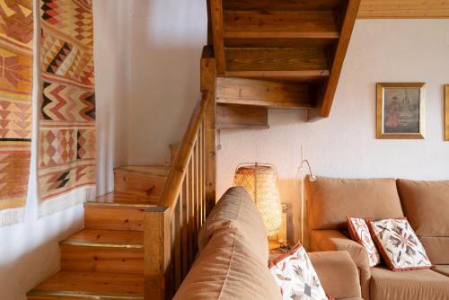 a living room with a couch and wooden stairs at Chalet de montaña con vistas in Prullans