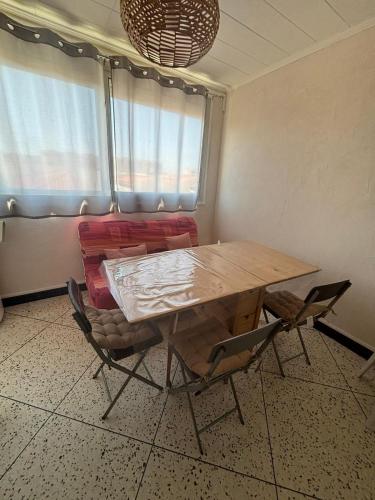 une salle à manger avec une table et des chaises en bois dans l'établissement L'Arbousier, à Port-la-Nouvelle