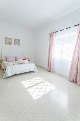 a white room with a bed and a window at Embrujo Andaluz Complejo Rural Órgiva in Órgiva