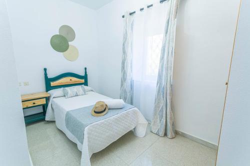 a bedroom with a bed with a hat on it at Embrujo Andaluz Complejo Rural Órgiva in Órgiva
