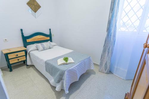 a bedroom with a bed and a table with a book on it at Embrujo Andaluz Complejo Rural Órgiva in Órgiva