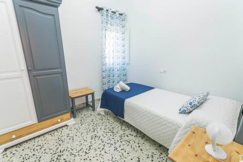 a small bedroom with a bed and a table at Embrujo Andaluz Complejo Rural Órgiva in Órgiva