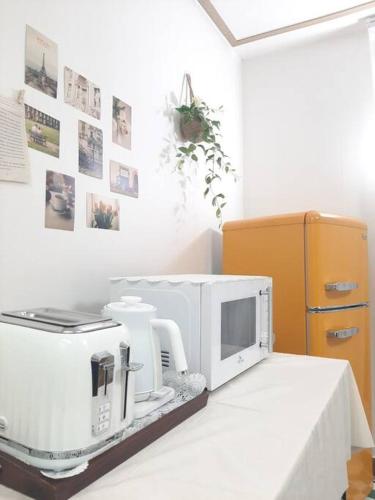 a kitchen with a microwave sitting on a table at Bliss Juju in Seoul