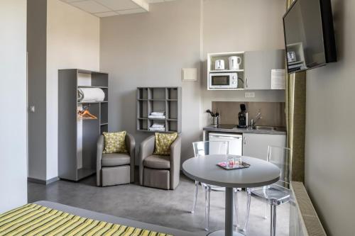 a kitchen with a table and chairs in a room at Smart Appart Caen République in Caen