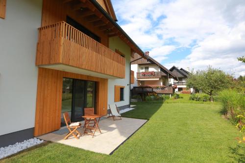 a patio of a house with two chairs and a table at Vila Nina Bohinj in Bohinj