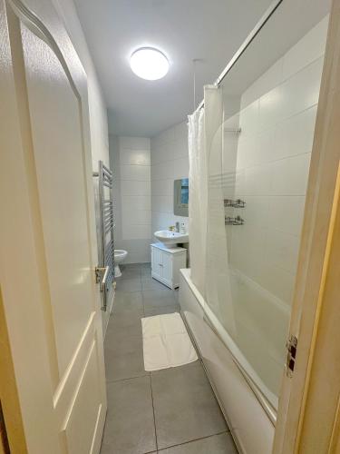 a bathroom with a shower and a toilet and a sink at Maple Street Apartments in London