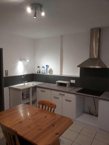 - une cuisine avec une table en bois et une cuisinière dans l'établissement l'Escale, à Thoissey