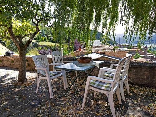 a group of chairs and a table and a tree at Chalet de montaña con vistas in Prullans