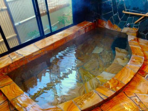 a large pool of water in a room with a window at Sansuisou in Hakone