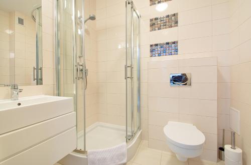 a bathroom with a shower and a toilet and a sink at ATRIUM Sarbinowo Na Fali in Sarbinowo