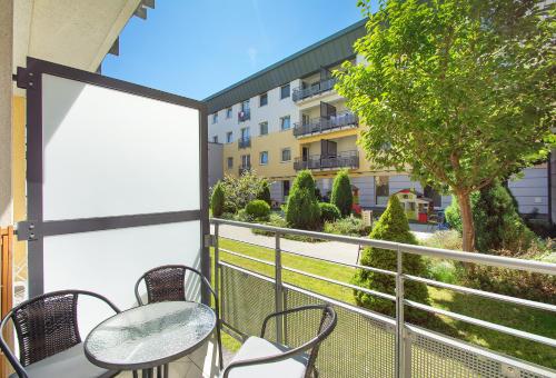 a balcony with tables and chairs and a building at ATRIUM Sarbinowo Na Fali in Sarbinowo