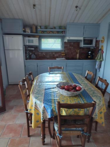- une cuisine avec une table et un bol de tomates dans l'établissement La Renardière, à Saint-Jurs