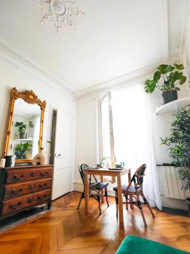 une salle à manger avec une table et un miroir dans l'établissement Heart of Paris - Chic et Cosy - opéra, à Paris
