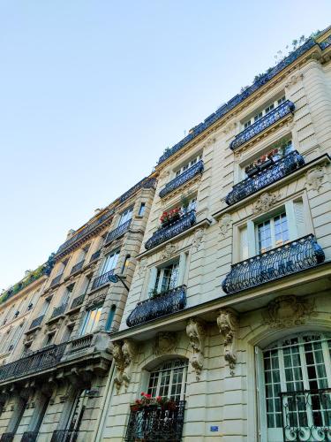 d'un grand bâtiment avec un balcon et des fleurs. dans l'établissement Heart of Paris - Chic et Cosy - opéra, à Paris