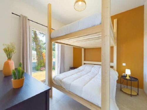une chambre avec un lit superposé et une grande fenêtre dans l'établissement Maison - 8 à 10 personnes les Grenettes, à Sainte-Marie de Ré