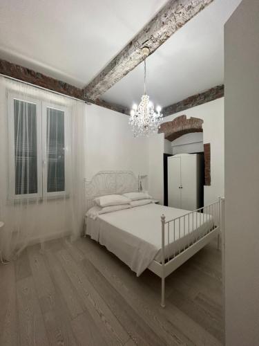 a white bedroom with a bed and a chandelier at Chez Sophie in La Spezia
