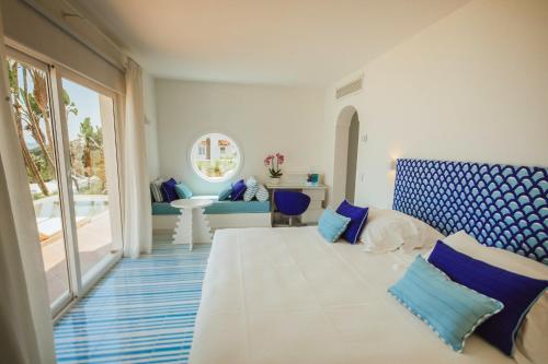 a bedroom with a large white bed with blue pillows at Hotel Continental Mare in Ischia