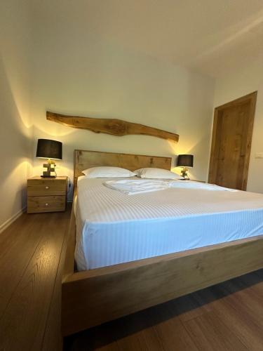 a bedroom with a large white bed with two lamps at Kantina & Ferma Dukat in Vlorë