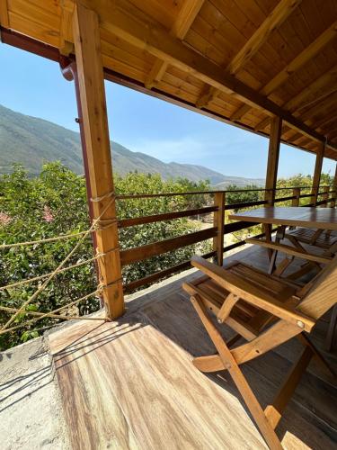 a wooden table and chair on a deck with a view at Kantina & Ferma Dukat in Vlorë