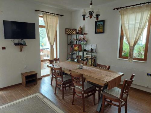 Un comedor con una gran mesa y sillas de madera. en Villa Victoria, en Stoykite