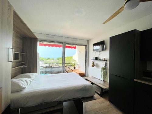 une chambre avec un lit et une grande fenêtre dans l'établissement PGH N4 - Vue Mer, Piscine & Parking Privé, à La Grande Motte