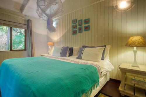 a bedroom with a large bed with a blue blanket at Mar Azul 5 in Ponta Malongane