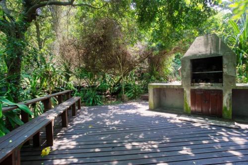 a wooden boardwalk in a park with a wooden bridge at Mar Azul 5 in Ponta Malongane