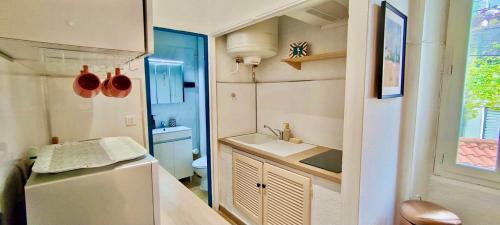 une petite cuisine avec un évier et un réfrigérateur dans l'établissement Joli studio à 1 minute de la mer, à Toulon