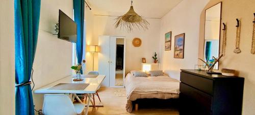 une chambre avec un lit et un bureau dans l'établissement Joli studio à 1 minute de la mer, à Toulon