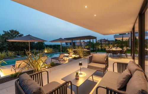Un patio con mesas y sillas y una piscina. en Lovely Home In Porec With Sauna, en Poreč