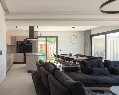 a living room with a couch and a table at Elia Villa, with Pool, SeaViews & Iconic Design, By ThinkVilla in Astérion