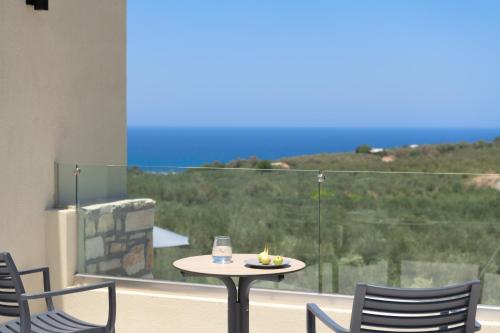 a table and chairs on a balcony with a view at Elia Villa, with Pool, SeaViews & Iconic Design, By ThinkVilla in Astérion