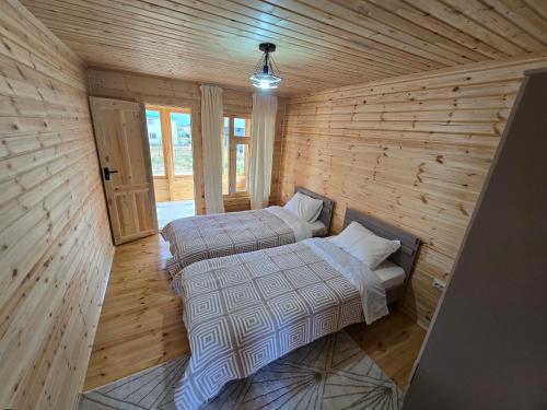 a bedroom with two beds in a wooden room at Wood House 2 in Bosteri