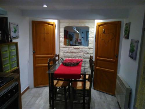 eine Küche mit einem Tisch und einem roten Tischtuch darauf in der Unterkunft Coquette petite maison de village in Aups