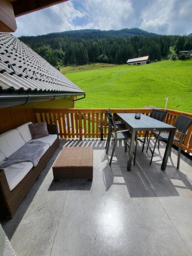a patio with a couch and a table and chairs at Appartement Edelweiss mit Infrarotkabine in Großsölk