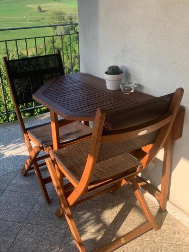 ein Holztisch und Stühle mit Blick auf ein Feld in der Unterkunft Il Gelso 'd la Costa in Lesegno