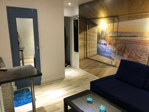 un salon avec un canapé et un miroir dans l'établissement Appartement quartier Sainte Marthe, à Paris