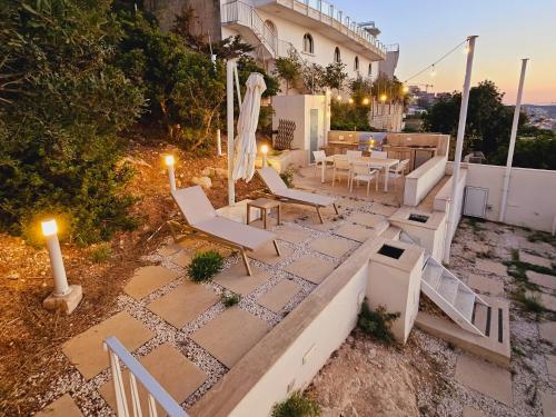 a patio with chairs and a table and a table and chairs at Villa Enchante - Heated Outdoor Pool in Mellieħa