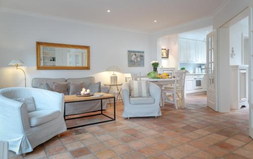a living room with a couch and chairs and a table at Moledyk in Westerland (Sylt)